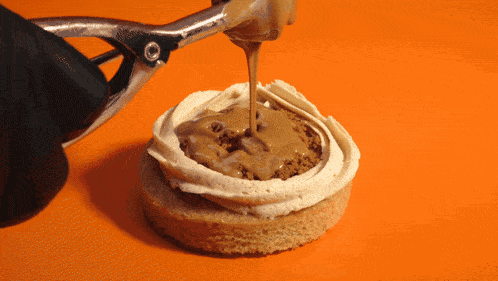 a close up of a cookie with frosting and caramel being poured on it