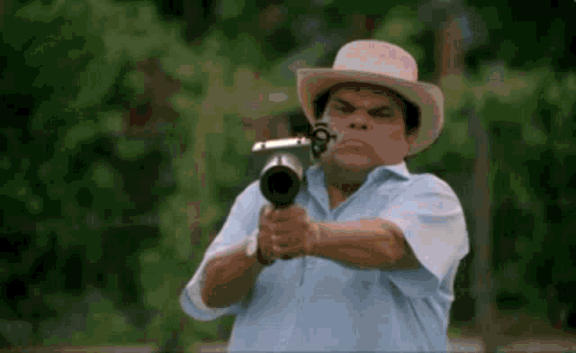 a man in a cowboy hat is pointing a gun at something .