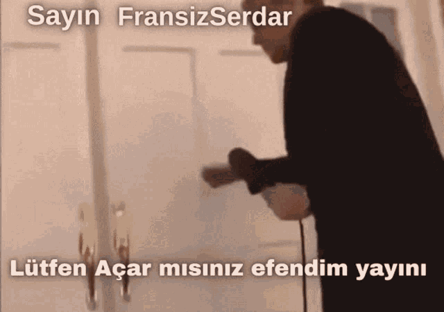 a man is standing in front of a door with the words sayin fransizserdar written on it
