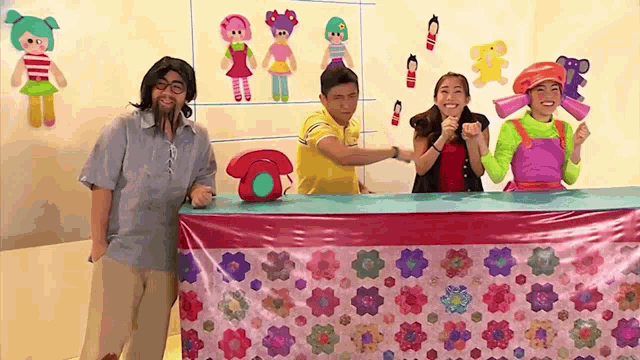 a group of people are standing around a table with a telephone on it
