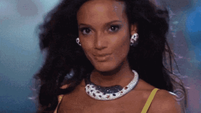 a close up of a woman wearing a necklace and earrings