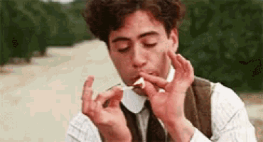 a man is lighting a cigarette with a match in his mouth