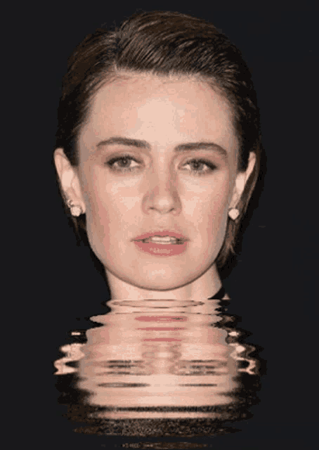 a close up of a woman 's face with a reflection in the water