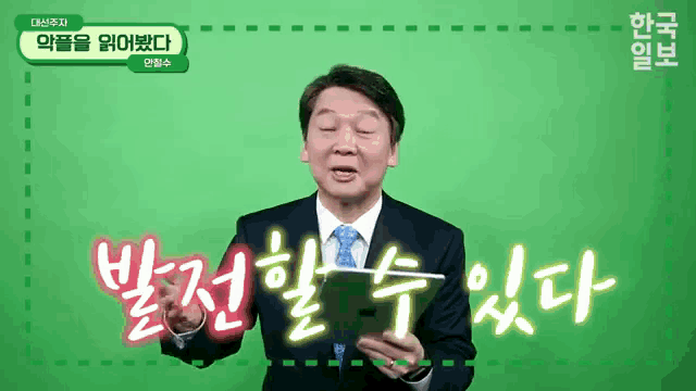 a man in a suit and tie is holding a tablet with korean writing behind him