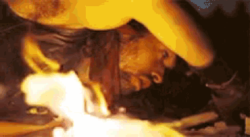 a close up of a person 's face with a flame coming out of it .