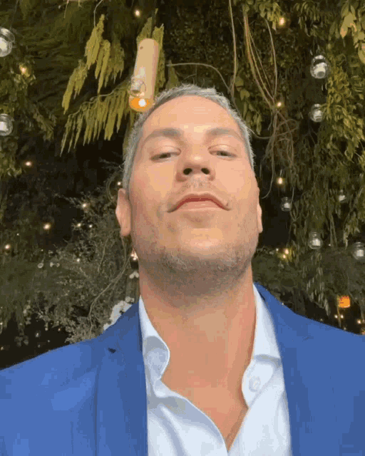 a man in a blue suit and white shirt looks up at something