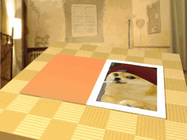 a picture of a dog wearing a red hat is sitting on a table