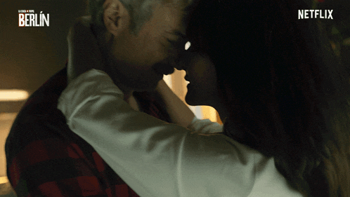a man and woman kissing in front of a sign that says netflix