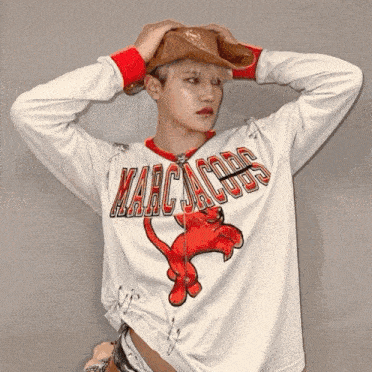 a person wearing a white marc jacobs shirt with a red cat on it