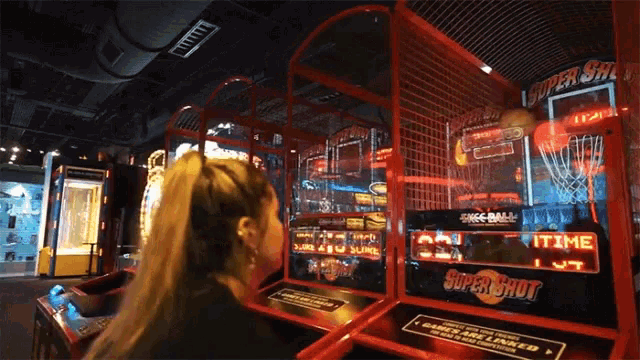 a woman is playing a super shot arcade game