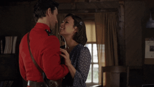 a man in a red uniform kisses a woman with the name andrew coppin written below them