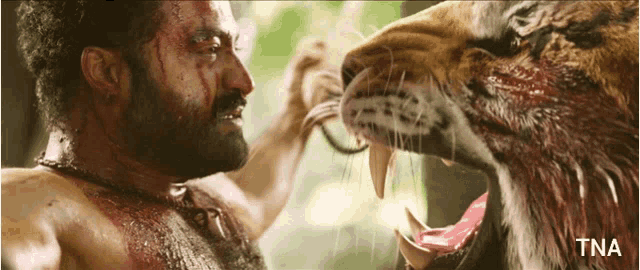 a man is being attacked by a tiger with tna written on the bottom of the image