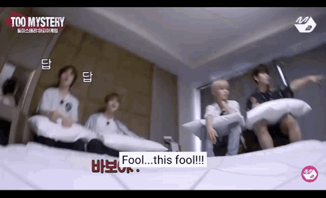 a group of young men are sitting on a bed and one of them is saying fool this fool .