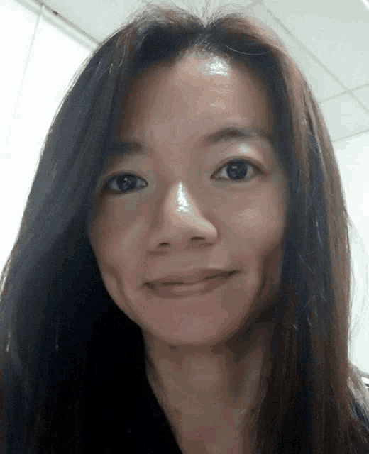 a close up of a woman 's face with long dark hair