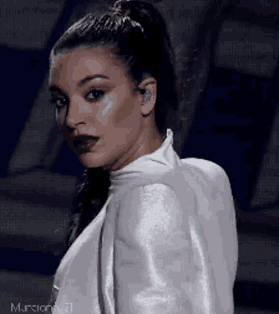 a woman with a ponytail wearing a white top