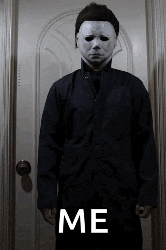 a man in a mask is standing in front of a door with the word me written below him