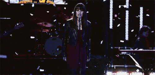 a woman stands in front of a stage that says s100