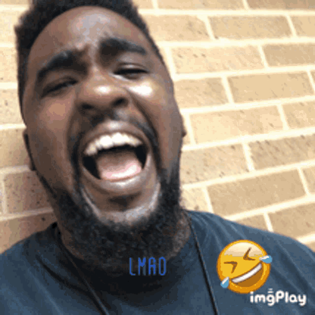 a man with a beard is laughing with the word lmao written on his shirt