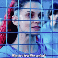 a woman with red hair is behind a fence and says why do i feel like crying .