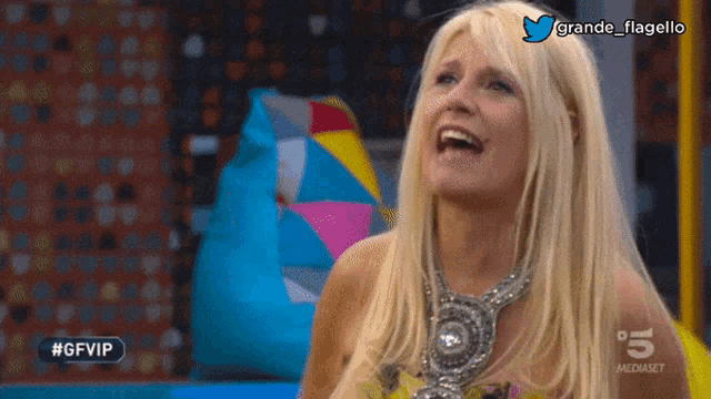 a woman with blonde hair is laughing in front of a blue bean bag chair with the hashtag #gfvip