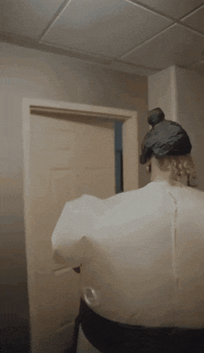 a person in a hoodie is standing in a doorway