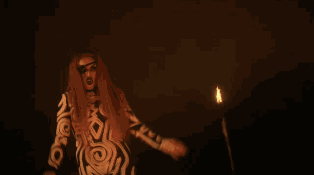 a woman in a black and white dress surrounded by flames
