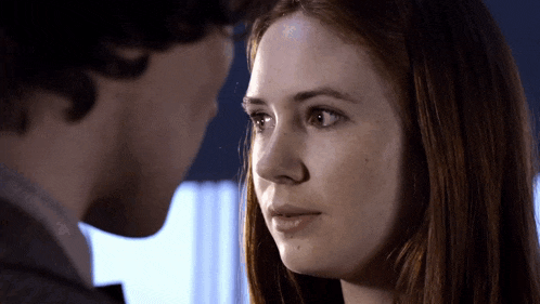 a close up of a woman 's face with a man 's face behind her