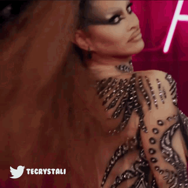 a woman with feathers in her hair is wearing a twitter icon
