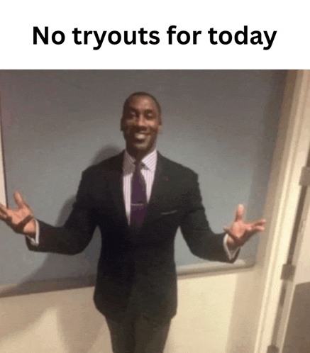 a man in a suit and tie is standing with his arms outstretched in front of a wall with the words no tryouts for today