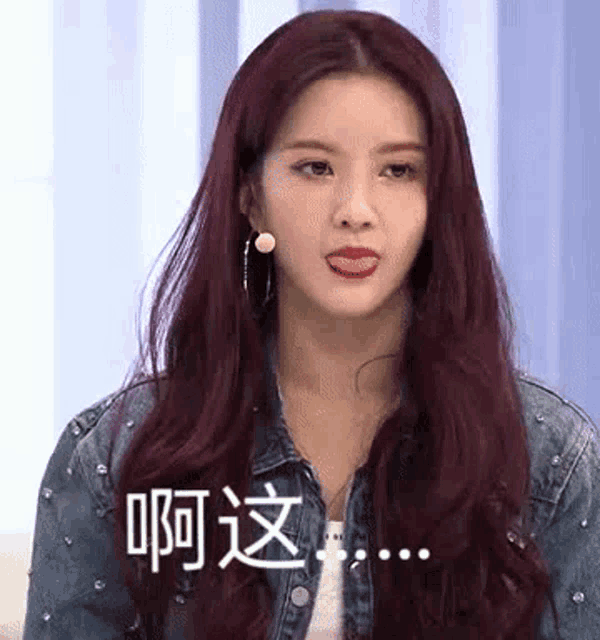a woman with red hair and a denim jacket is making a funny face .