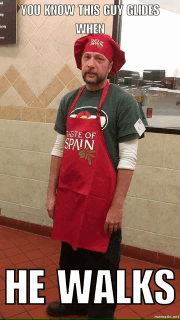 a man wearing an apron that says taste of spain is standing in front of a window