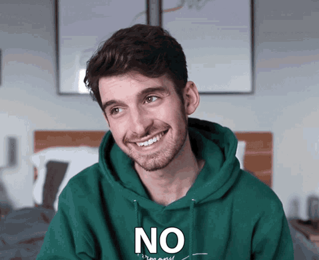 a man wearing a green hoodie that says " no " on it