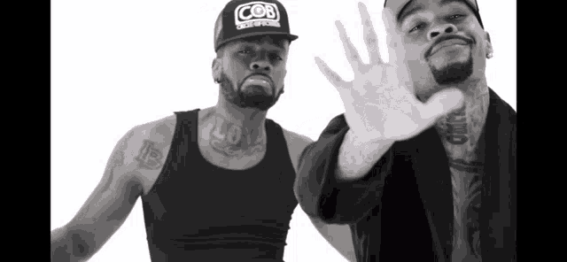 a man wearing a hat that says cob stands next to another man