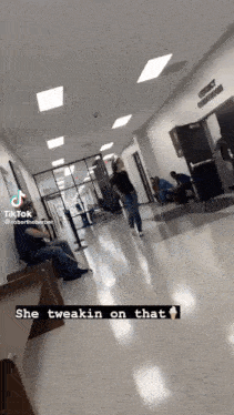 a woman walking down a hallway with a caption that says she tweekin on that