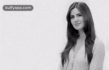 a woman with long hair is standing in front of a white background and smiling .