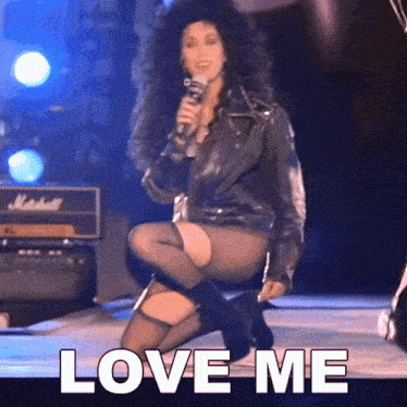 a woman singing into a microphone with the words love me on the bottom