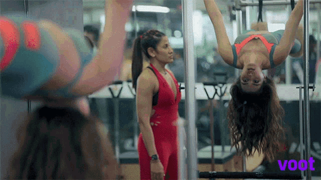 a woman hanging upside down in a gym with the word voot on the bottom left