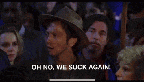 a man in a hat says oh no we suck again in front of a crowd of people