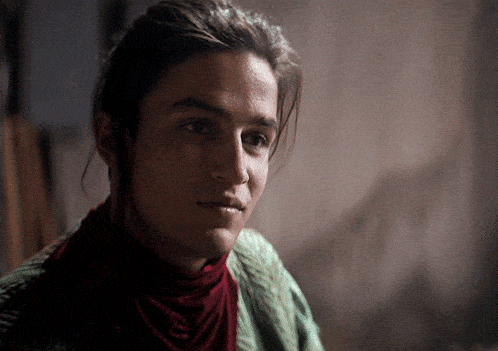 a close up of a person 's face with a red scarf around his neck