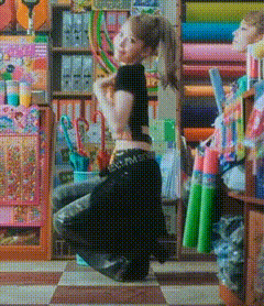 a woman in a black crop top is kneeling down in front of a store