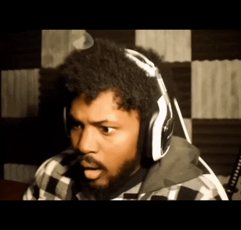 a man with a beard wearing headphones and a plaid jacket