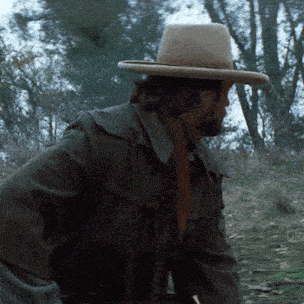 a man wearing a cowboy hat and a brown scarf