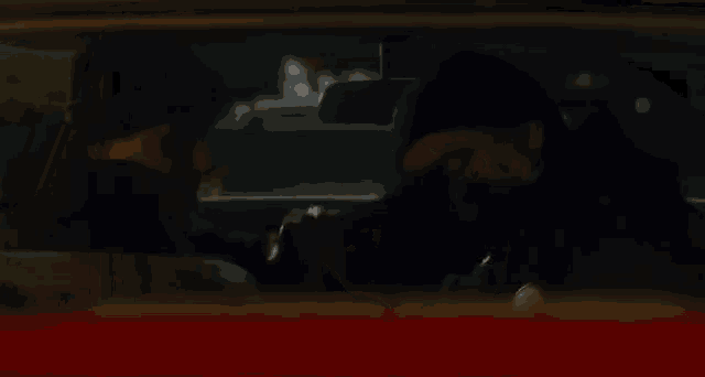 two men are sitting in a car talking to each other .