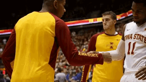 two iowa state basketball players shake hands with a player from another team