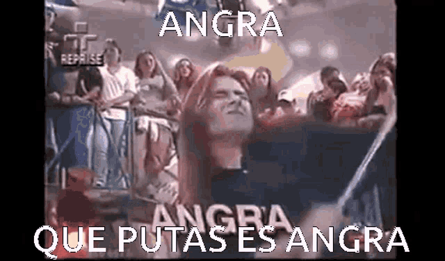 a group of people are watching a wrestling match and the words angra que putas es angra are written on the screen