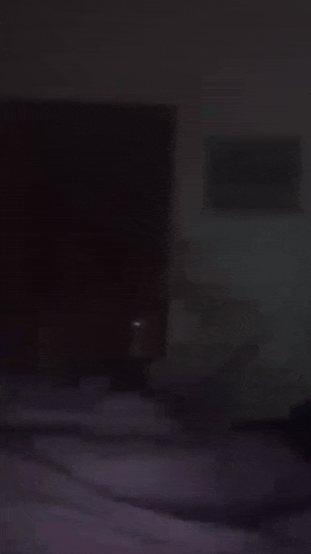 a person is laying on a bed in the dark