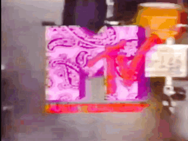 a blurred image of a mtv logo with a pink paisley design