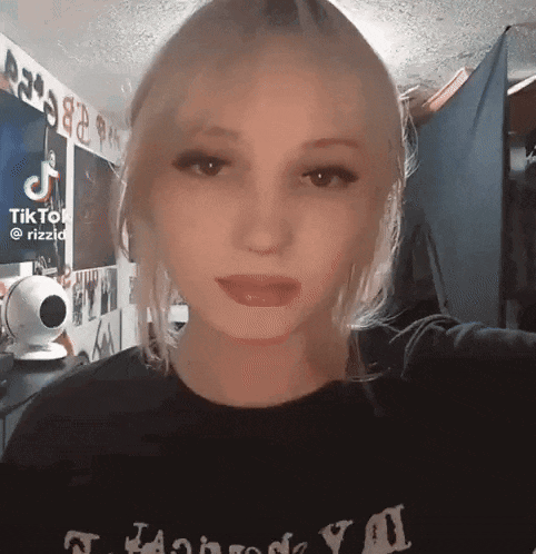 a girl is taking a selfie in a room with a camera .