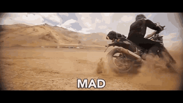 a man is riding a dirt bike in the desert and the word mad is on the screen