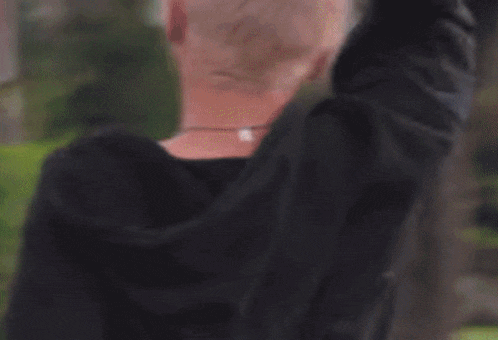 a blurry picture of a woman 's back with a man 's arm around her shoulder